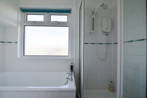 Ground floor bathroom off the utility area at The Buck with bath and shower cubicle and wash basin only