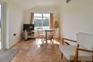 The garden room at The Buck with table and chairs and tv