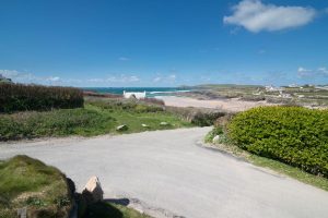 View over the beach and ocean from the bottom of the garden at The buck