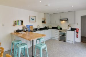 Open plan kitchen area with breakfast bar and stools