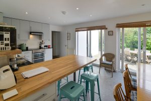 Open plan kitchen and dining areas at The Riding with glass doors from both the dining and kitchen areas onto the rear patio