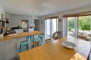 Open plan kitchen and dining areas at The Riding with glass doors from both the dining and kitchen areas onto the rear patio