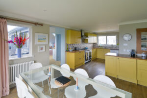 Open plan kitchen and dining area at Torridon with dining table and chairs