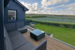 View from the balcony at Torridon over the fields to the rear of the house with outdoor seating