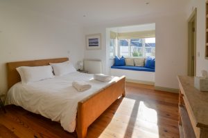 The master king ensuite bedroom with window seat at Tregarne and window to the rear of the house