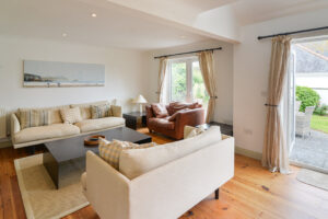 Seating in the lounge at Tregarne with double doors leading onto the rear garden patio