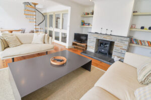 The lounge at Tregarne with spiral staircase to the mezzanine and doors to the entrance hall