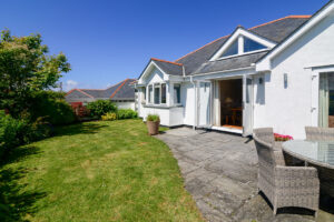The rear grassed lawn and patio at Tregarne