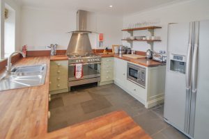 The kitchen area at Tregarne with large oven and hob, microwave and fridge freezer