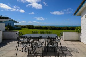 Patio with seating and sea views at the rear garden of Atlantic Breezes