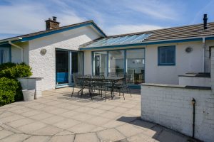 View of exterior rear of Atlantic Breezes with patio and seating