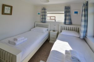 Twin bedroom at Wings with windows to front and side of house