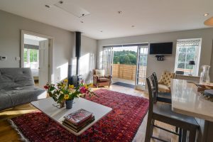 Patio doors leading outside with log burner and mounted TV at The Studio at Pensile House