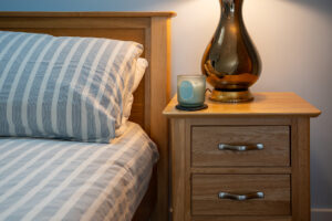 Bedside table and lamp in master bedroom at Carrek Cottage