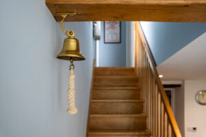Hanging bell above stairs to first floor at Carrek Cottage