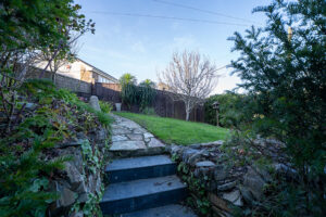 Grassed area with path and shrubs at Carrek Cottage