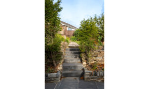 Patio steps leading up to grassed garden area at Carrek Cottage