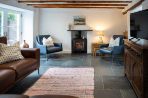 Lounge with log burner, TV and patio doors at Carrek Cottage