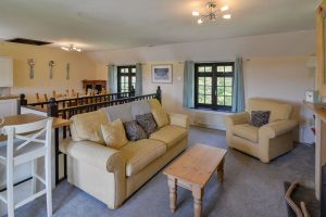 First floor lounge area with seating at Stable Cottage