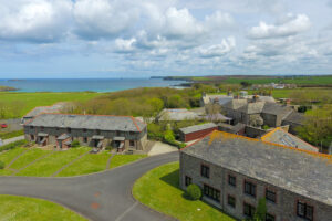 Area view of the Stable Cottage and other properties in the vicinity and view of the coastline