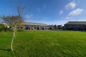 Front of Stable Cottage and adjoining properties from the communal grassed area with The Pig restaurant in the background