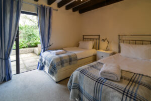 Ground floor twin room at Stable Cottage with door to rear outside area