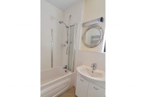 Bathroom on the ground floor at Stable Cottage showing bath with shower over, wash hand basin