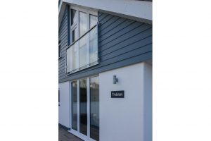 Front exterior of Trebriani with house name on sign o the wall