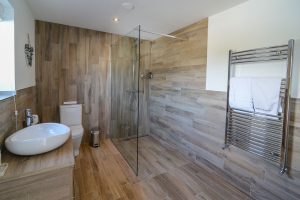 The shower room off the entrance hallway at Trebriani with large shower toilet and wash basin