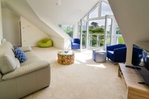 The first floor lounge at Trebriani with large glass floor to ceiling window with opening doors and Juliet balcony