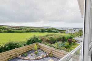 View over the rear garden toward Trevose Head from the Juliet balcony off the first floor lounge at Trebrian