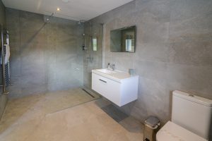 The ensuite to the ground floor twin bedroom at Trebriani with large shower toilet and wash basin