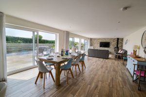 Open plan dining and lounge area at Trebriani with large doors onto the rear patio