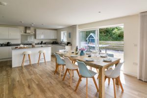 Open plan dining and kitchen areas at Trebriani with large sliding doors onto the rear patio