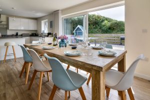 Open plan dining and kitchen areas at Trebriani with large sliding doors onto the rear patio