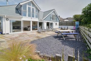 Rear exterior of Trebriani with large patio and gravelled area with outside furniture