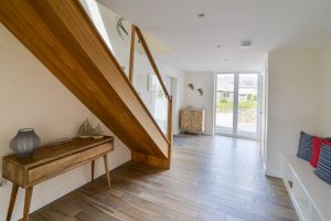 The large entrance area at Trebriani with floor to ceiling window stairs to the first floor and fitted seating area