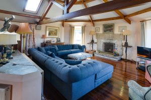 Large sofas with fire place, oak beams and TV in lounge at The Granite House
