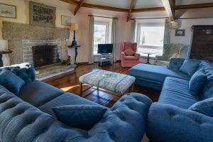 Large lounge with TV and open fireplace at The Granite House