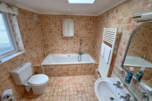 Ensuite bathroom from the master bedroom with bath and handheld shower facility, toilet and wash basin