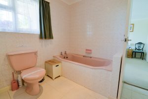 The shared ensuite at Tamarisk showing bath and toilet and door to the first twin bedroom
