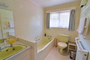 Ensuite bathroom off the king bedroom at Tamarisk with bath, toilet and wash basin