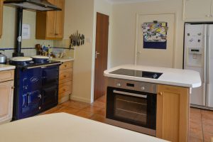 Aga and kitchen island with built in electric oven and hob at Tamarisk