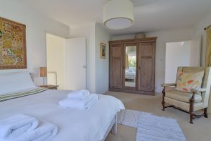 The master king ensuite bedroom at The Ridings with large wardrobe and comfortable chair