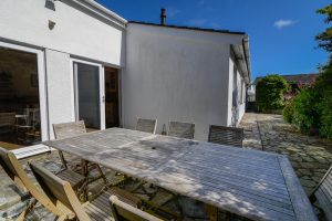 Rear patio and outside dining furniture at The Ridings with sliding doors into the kitchen and dining area