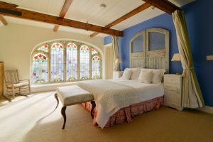 Master mezzanine bedroom at Church House with stained glass windows