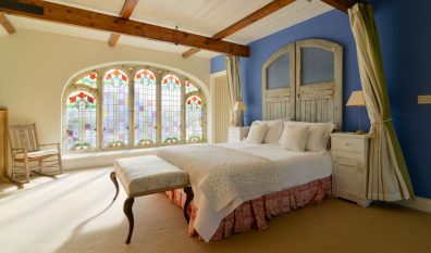 Master mezzanine bedroom at Church House with stained glass windows
