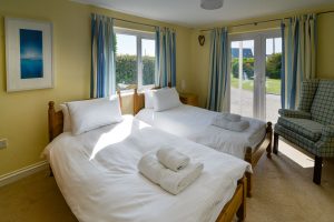 Ground floor twin bedroom at Little Tremawr with patio doors