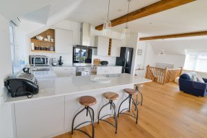 First floor open plan kitchen with bar stools at Little Tremawr