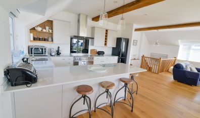 First floor open plan kitchen with bar stools at Little Tremawr